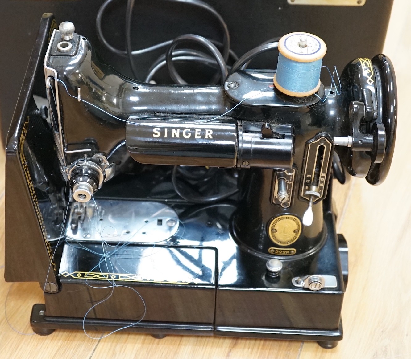 A cased portable Singer Featherweight 222K sewing machine with accessories